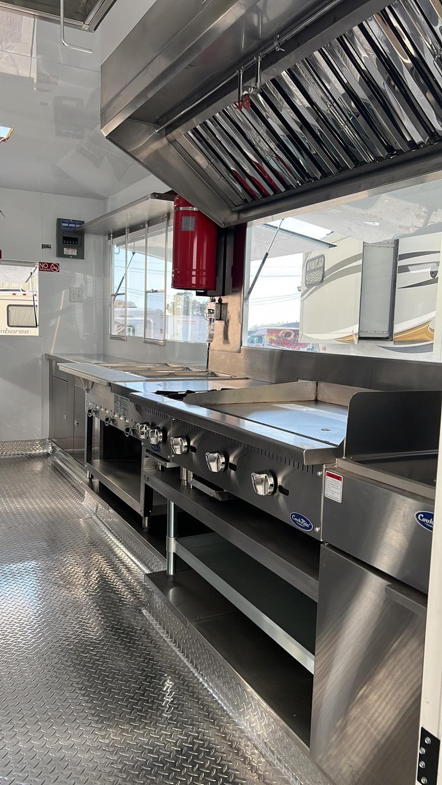 Commercial cook line and extraction hood inside a finished food trailer